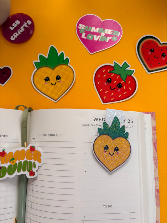 Glossy white cardstock magnetic bookmark with the image of a heart shaped kawaii pineapple.
