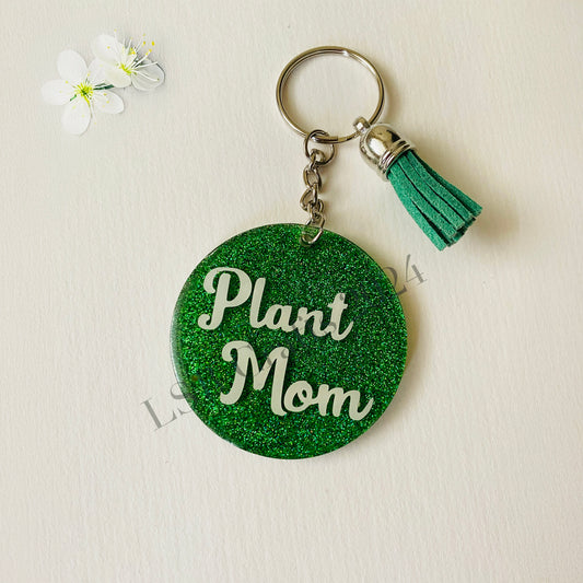 Plain Green Background (glossy) with White Vinyl (glossy) and Green Tassel.

Design details on the acrylic keychain is personalised with the text Plant Mom.