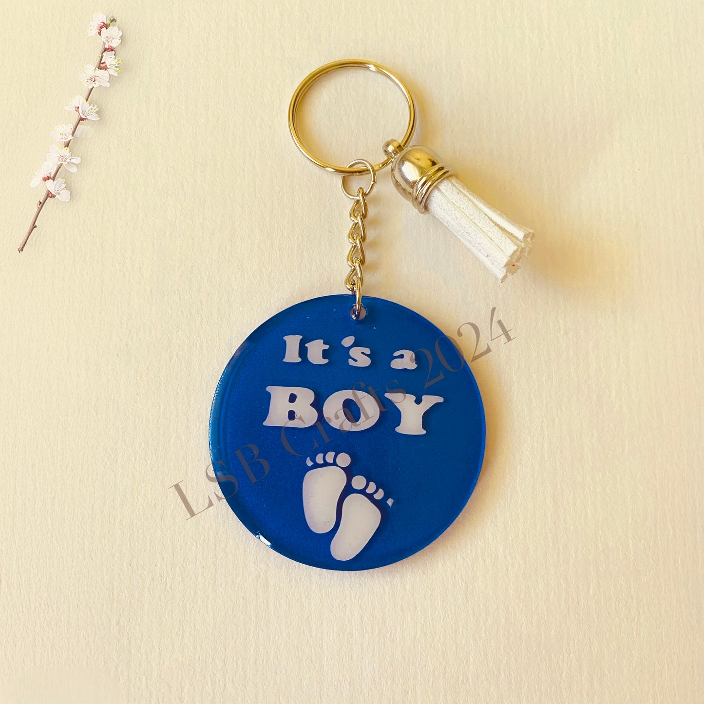 Plain Blue Background (matte) with White Vinyl (glossy) and White Tassel.

Design details on the acrylic keychain is personalised with the text It’s A Boy.