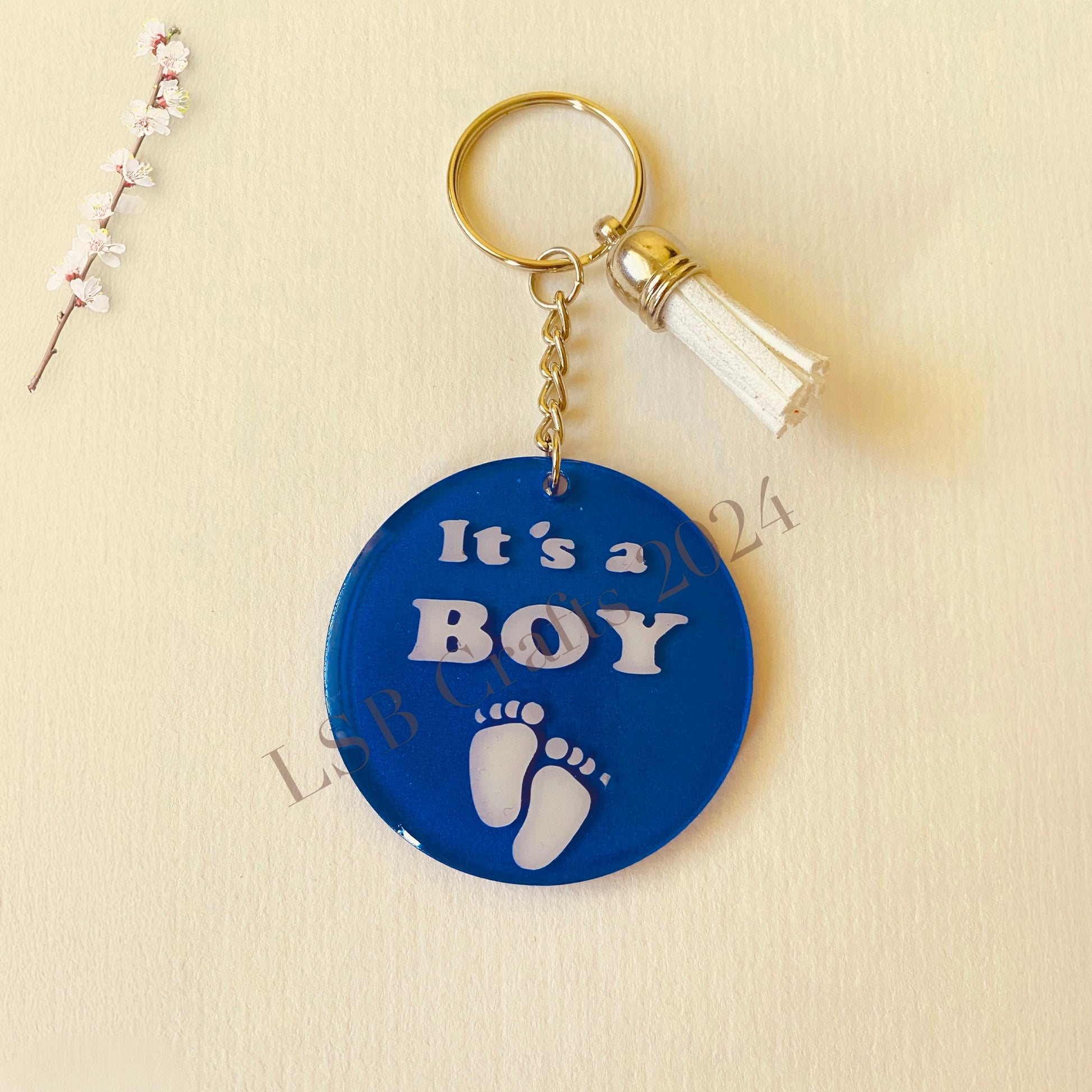 Plain Blue Background (matte) with White Vinyl (glossy) and White Tassel.

Design details on the acrylic keychain is personalised with the text It’s A Boy.