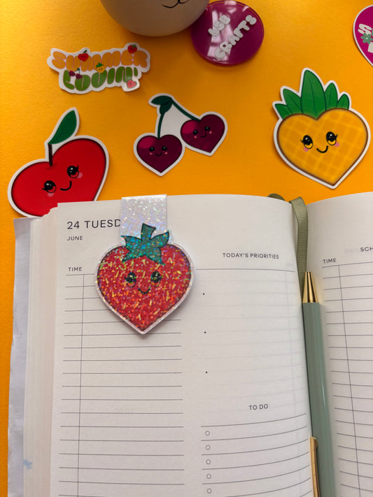 Glossy white cardstock magnetic bookmark with the image a heart shaped kawaii strawberry.